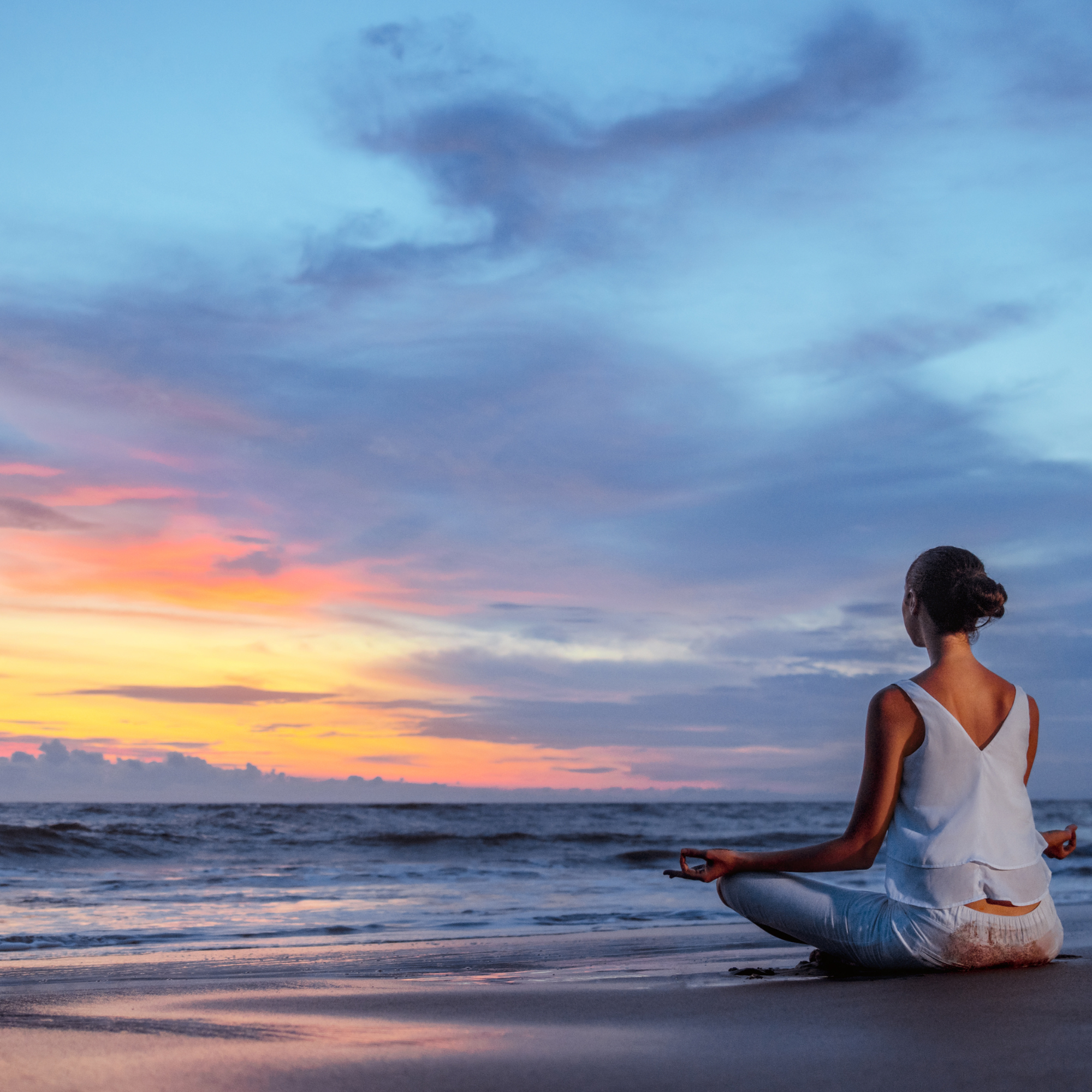 Meditando frente al mar en el atardecer